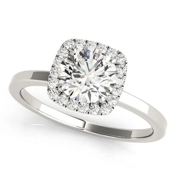 A white gold halo engagement ring with a round brilliant center diamond framed by a cushion-shaped halo of smaller diamonds